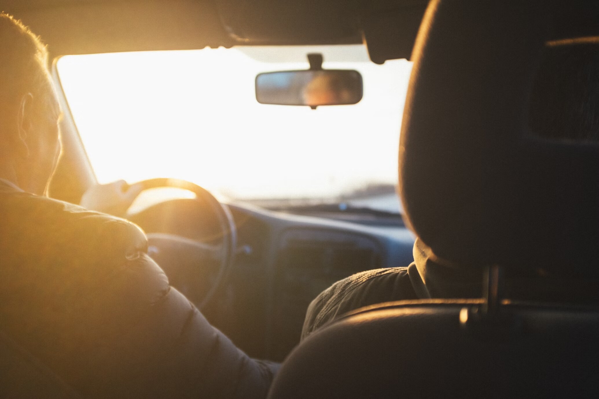 Man driving car during golden hour