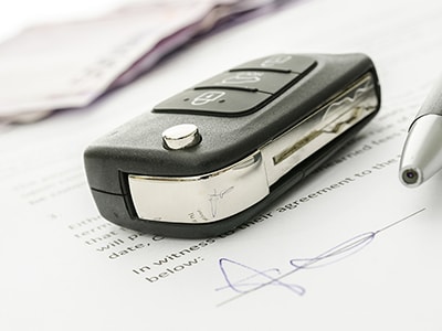 Close-up of a modern car key fob on signed paperwork