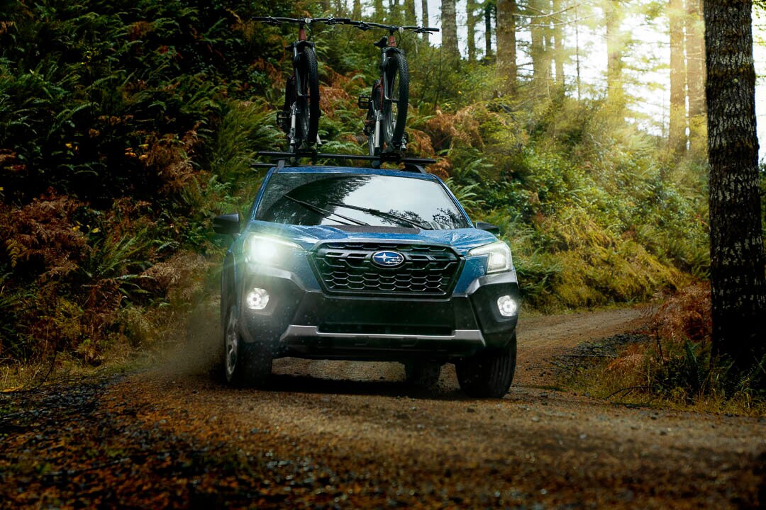 Un VUS Subaru Forester 2022 modèle Wilderness incluant ses phares à DEL avant, roule en nature.