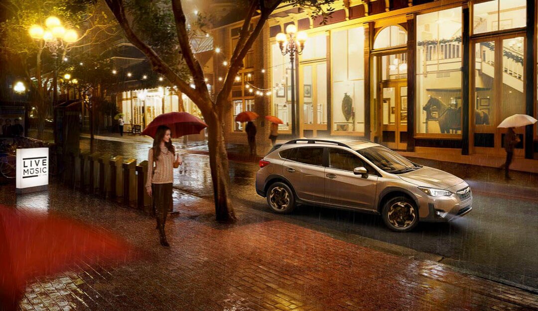 Un VUS Subaru Crosstrek 2022 sur une rue en ville roulant sous la pluie