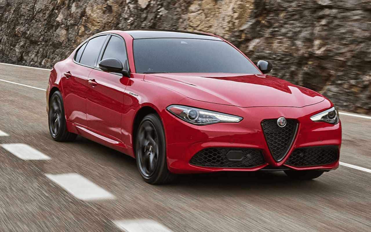 front side view of a 2023 Alfa Romeo Giulia on a road along a rocky wall