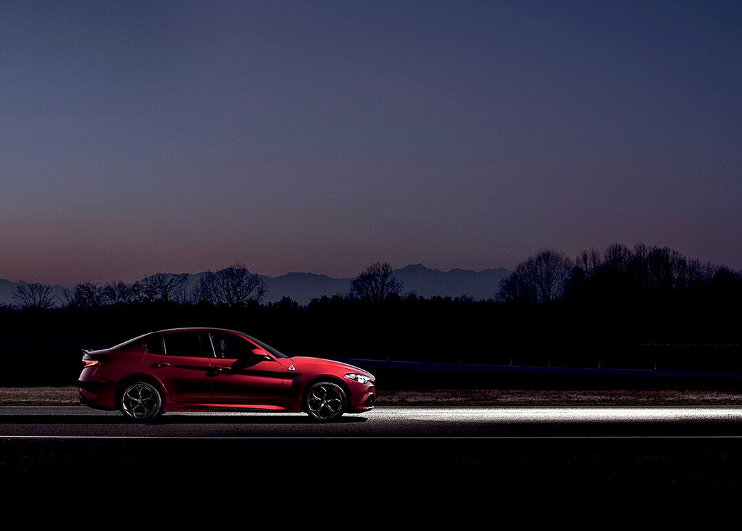vue latérale de l'Alfa Romeo Giulia Quadrifoglio 2021 sur une route la nuit