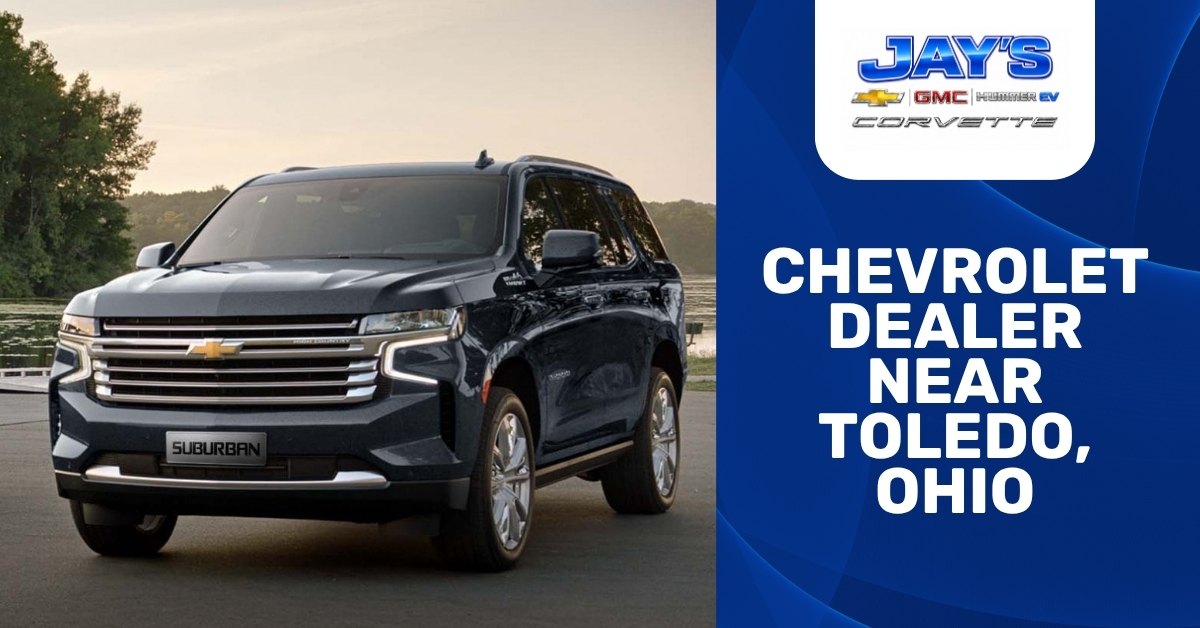 Promotional banner for Jay’s Chevrolet GMC dealership near Toledo, Ohio, featuring a dark blue Chevrolet Suburban parked by the water alongside dealership branding for Chevrolet, GMC, Hummer EV, and Corvette.