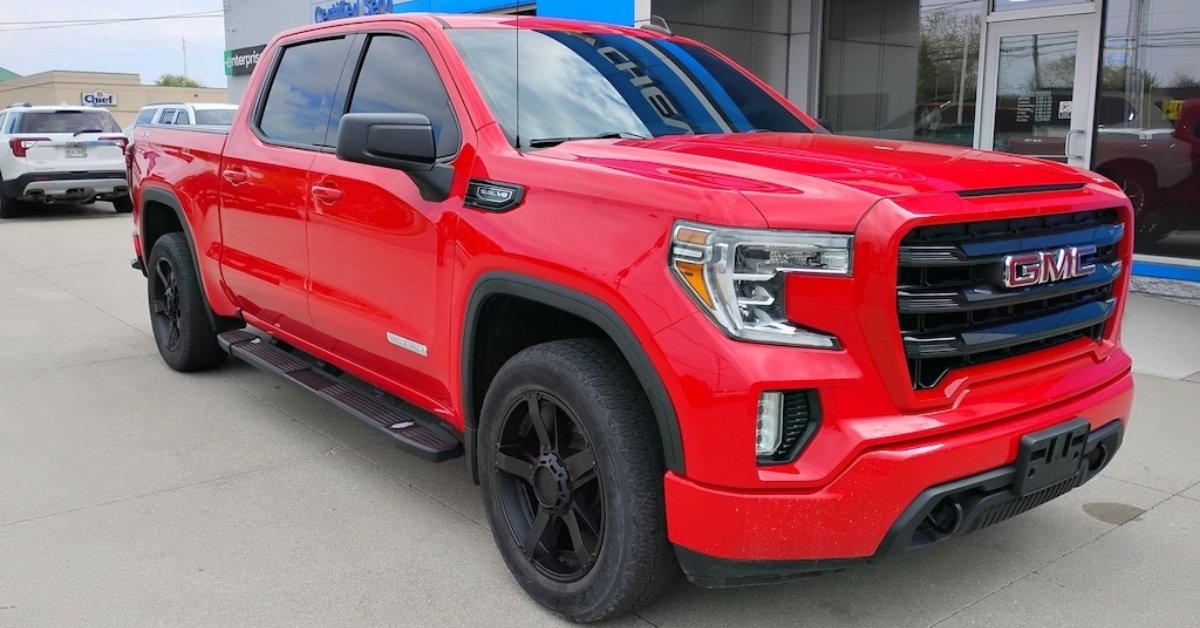 Bright red 2019 GMC Sierra 1500 Elevation pickup truck with black wheels parked at Don's Chevrolet GMC dealership lot, a GMC dealership near Toledo, OH, in daylight.
