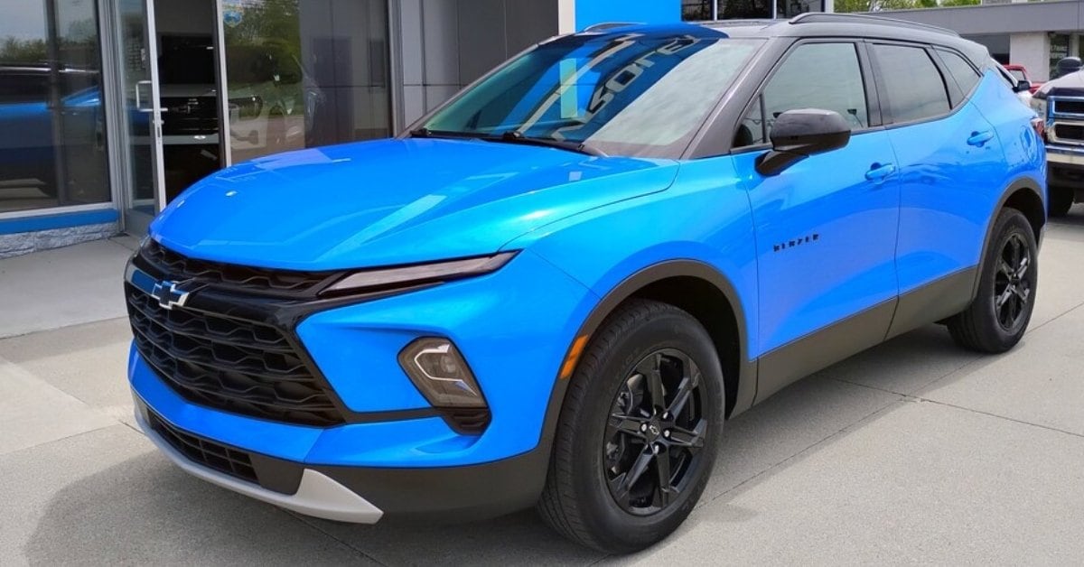 Blue 2024 Chevrolet Blazer LT with a black roof and black wheels parked outside of Jay's Chevrolet GMC in a three-quarter front view on a concrete lot.
