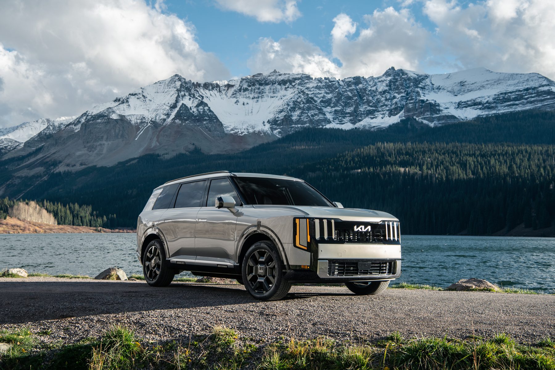 A silver 2027 Kia Telluride parked beside a mountain lake