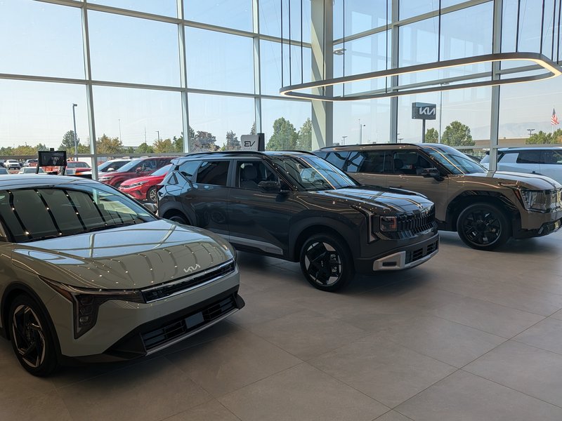 Kia SUVs parked inside the glass-walled Doug Smith Kia showroom