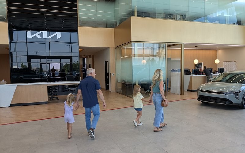 A family walking into the Doug Smith Kia showroom