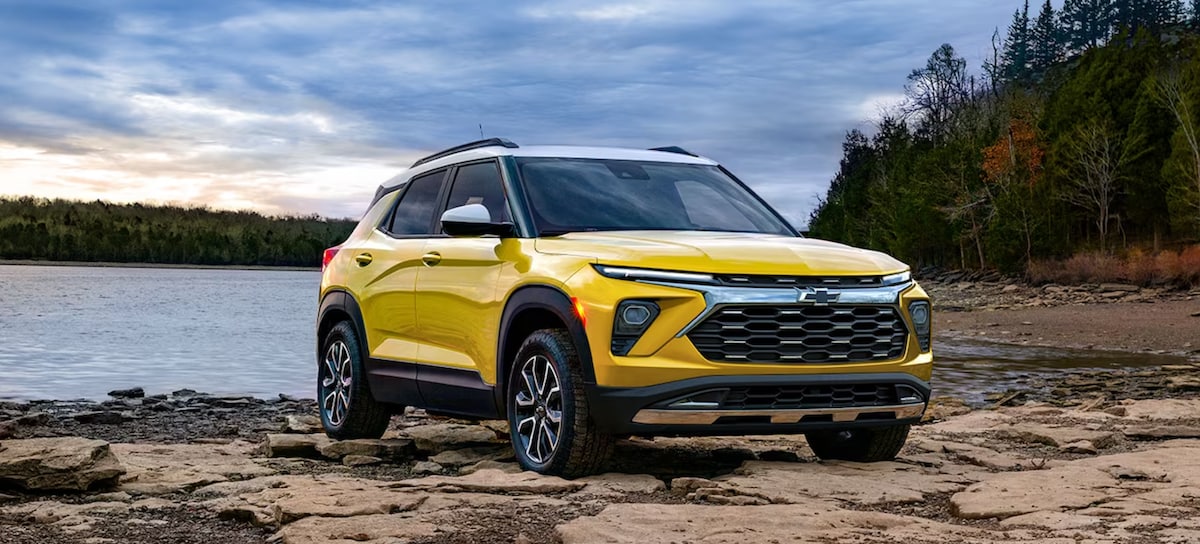 Yellow 2024 Chevy Trailblazer parked in front of water and trees