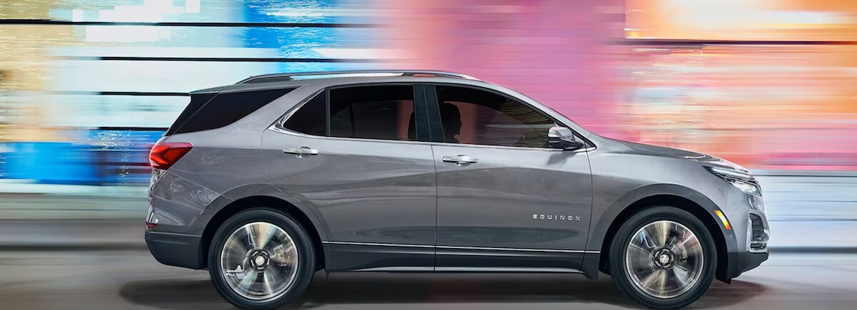 2024 Chevy Equinox driving past a multicolor background