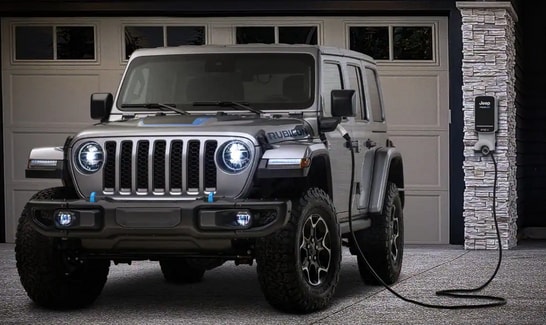 2023 Jeep Wrangler-4xe in gray parked at in a garage at a charging station