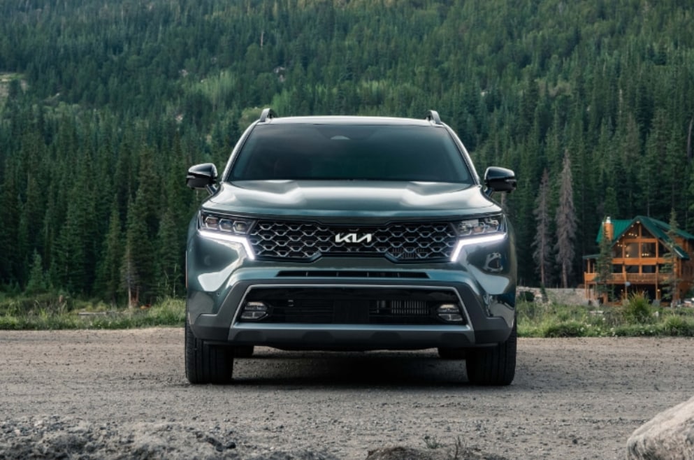 2023 Kia Sorento Hybrid SX Prestige parked near a cabin in the woods
