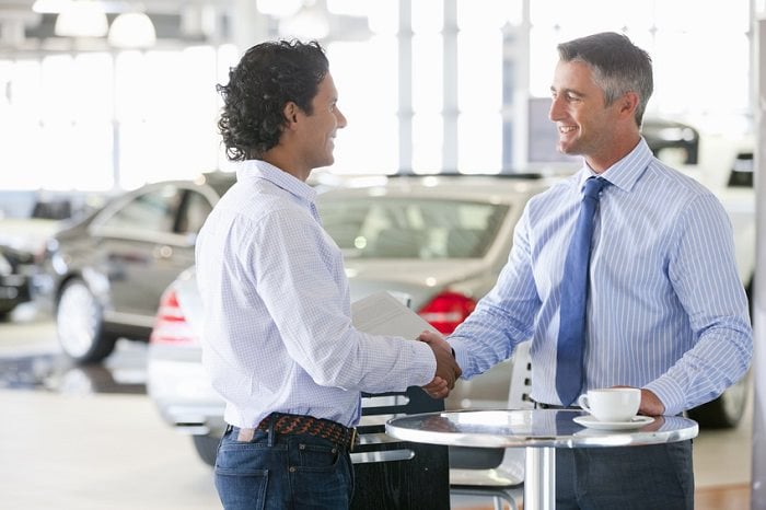 dealer and client shake hands