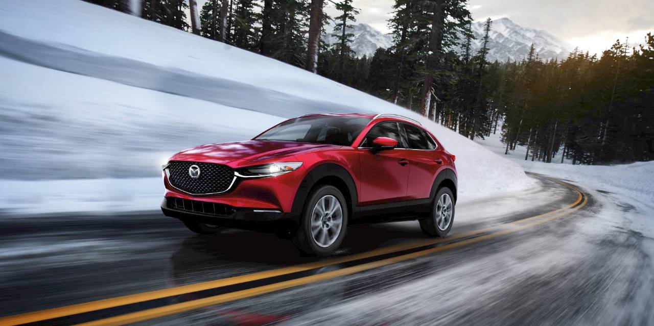 Red Mazda CX-30 driving in winter conditions