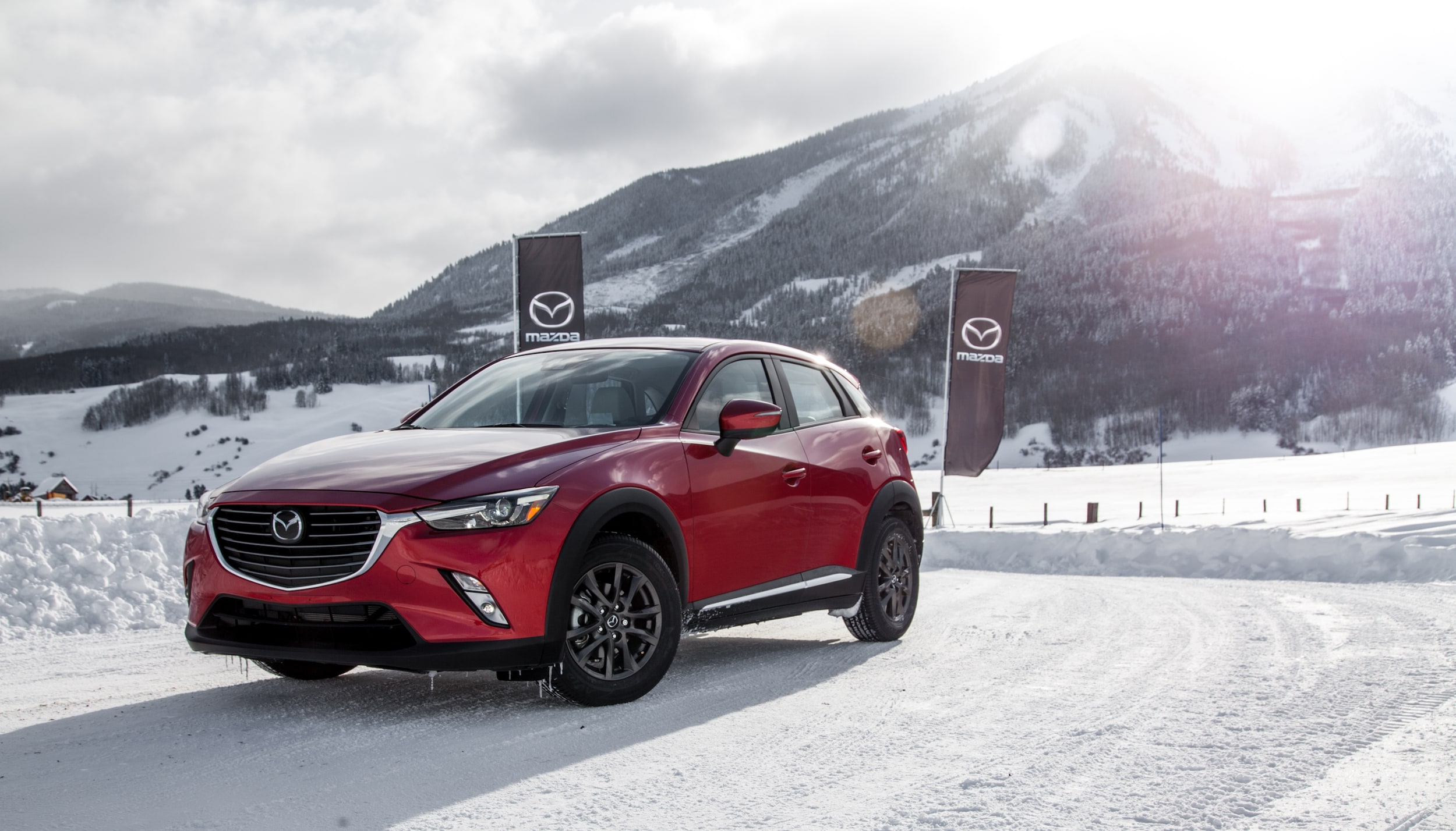 Red Mazda SUV in snowy driving conditions