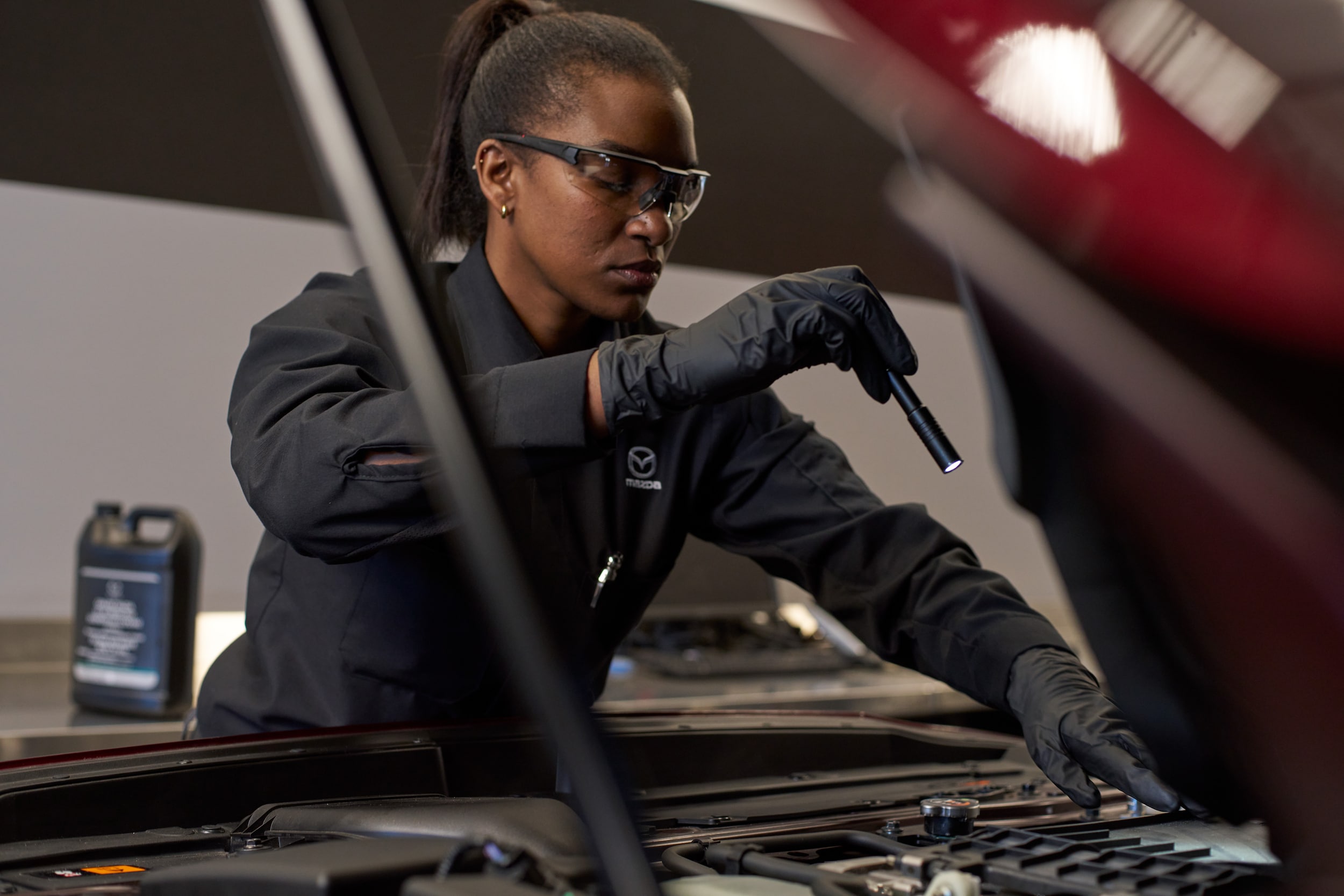 Mazda technician inspecting engine