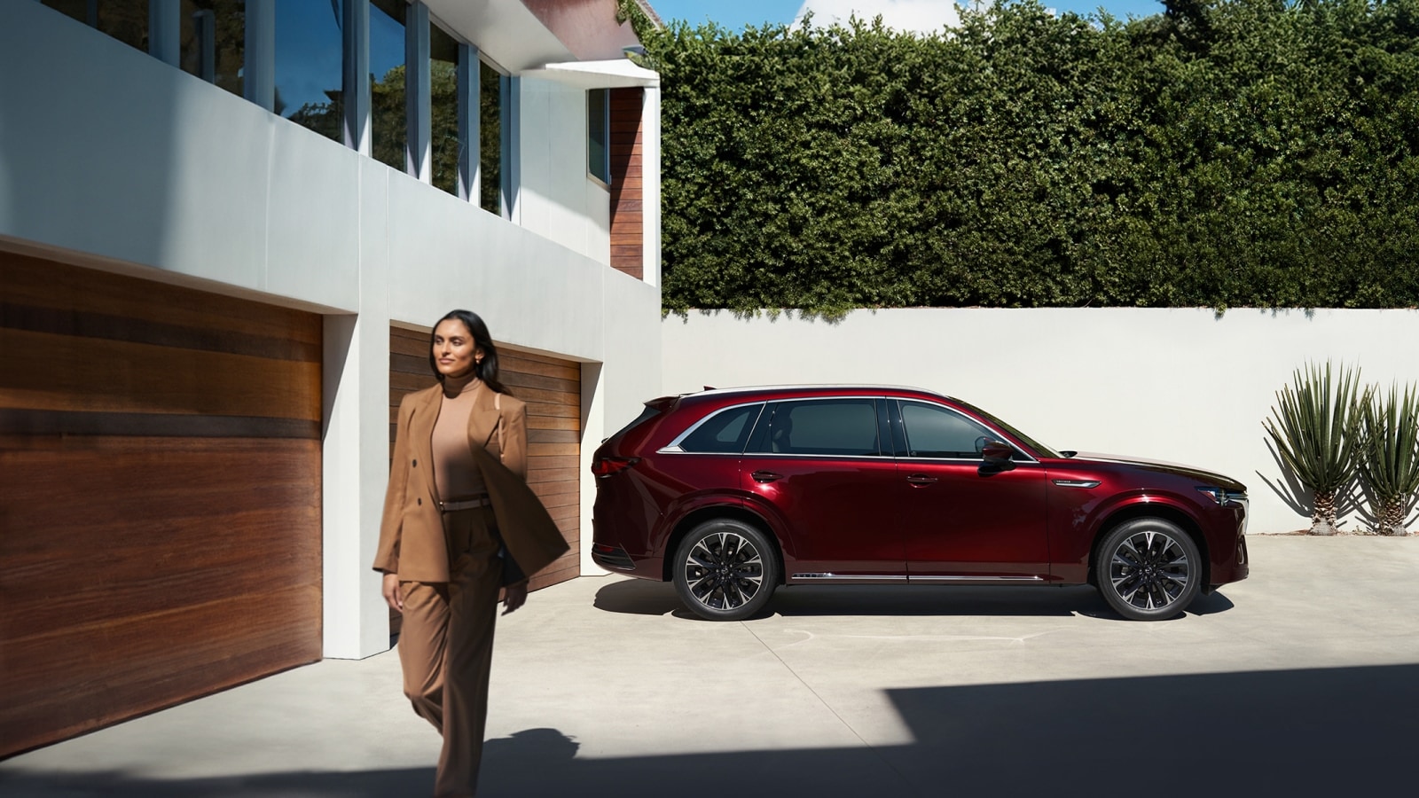 red 2026 Mazda CX-90 parked at home with a woman