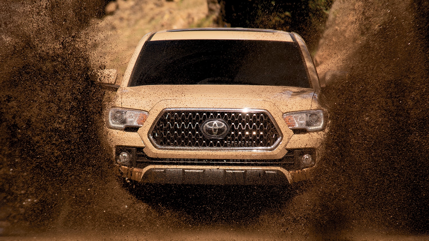 white 2019 Tacoma driving off road through the mud