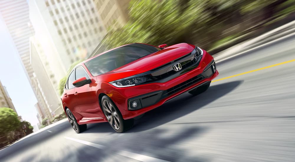 A red 2019 Honda Civic is shown driving on a highway after leaving a used Honda dealer.