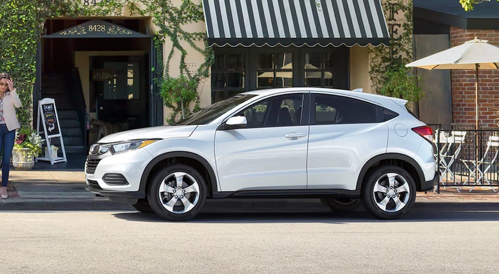 A white 2022 Honda HR-V LX is shown from the side parked next to a cafe.