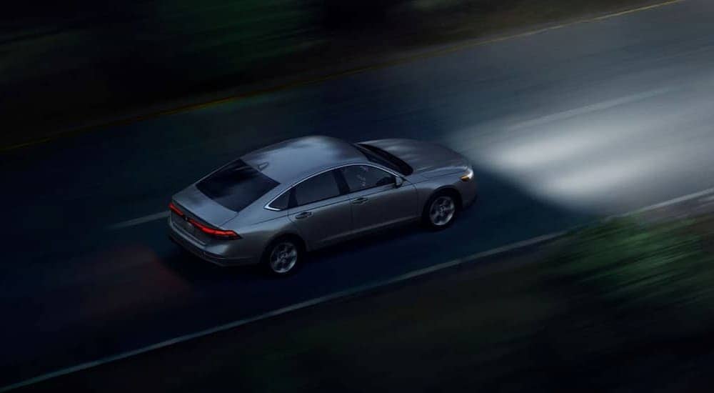 A silver 2024 Honda Accord LX is shown driving to visit a Farmerville Honda dealer.