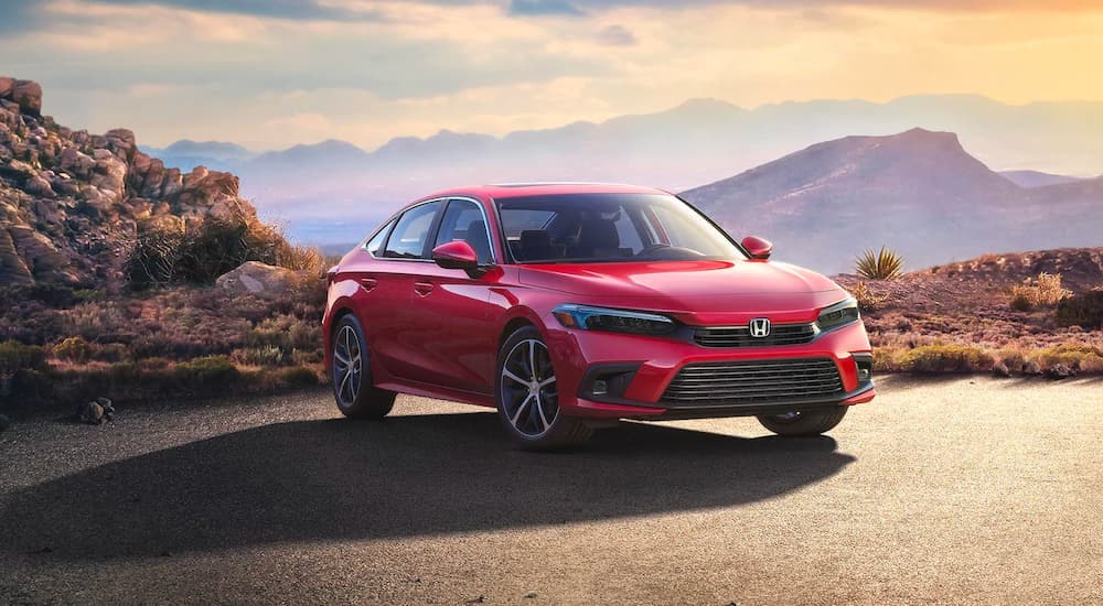 A red 2024 Honda Civic Touring is shown parked near a cliff.