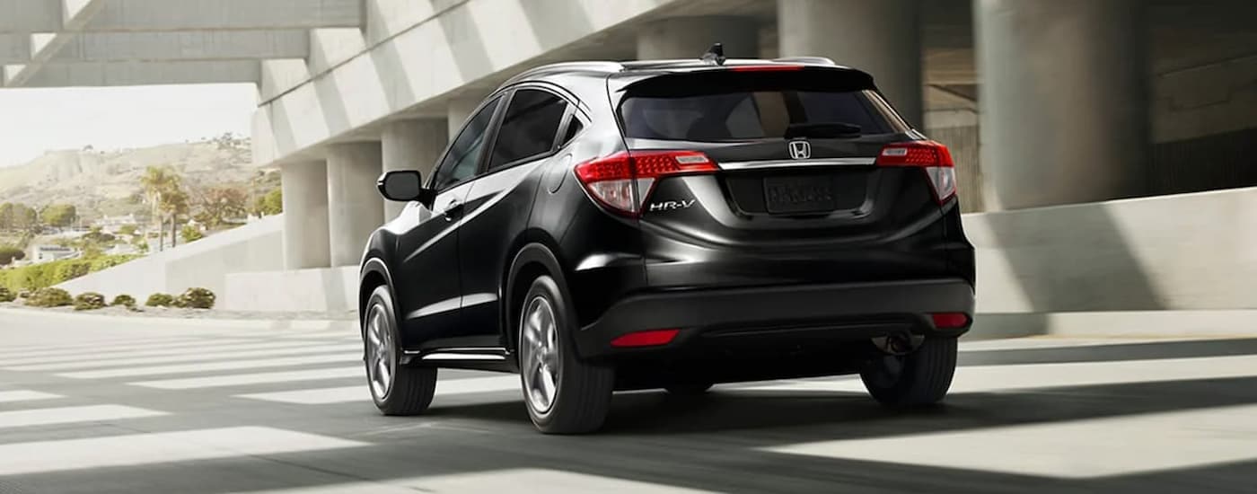 A black 2020 Honda HR-V EX-L is shown from the rear driving under a concrete overpass.