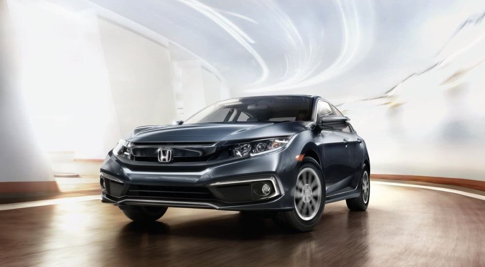 A grey 2019 Honda Civic driving in a brightly illuminated tunnel.