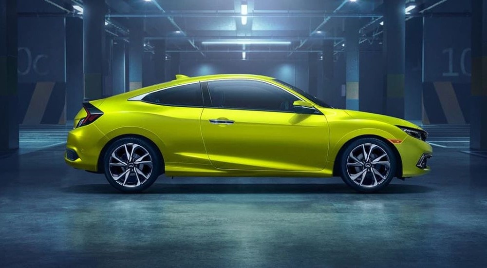 A lime green 2019 Honda Civic Touring parked in a warehouse.