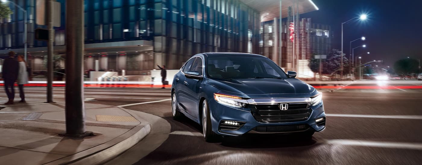 Used%20Cars%20for%20Sale%20-%202022%20Honda%20Insight%20Touring%20-%20Corner.jpeg A blue 2022 Honda Insight Touring driving around a city corner at night.
