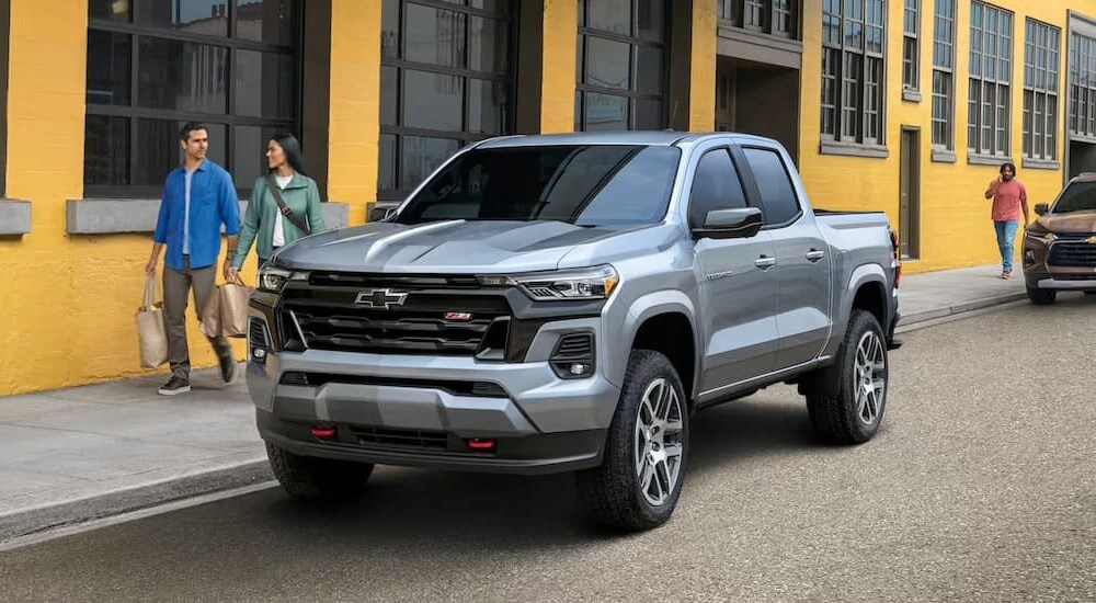 A silver 2023 Chevy Colorado Z71 is shown parked near a yellow building.