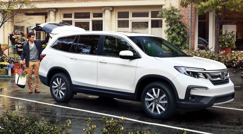 A white 2020 Honda Pilot is shown parked near a store after visiting a used Honda dealer near El Dorado.