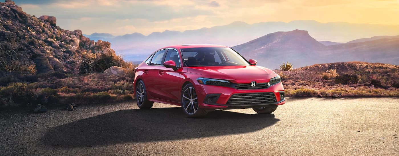A red 2023 Honda Civic Touring parked in the mountains.