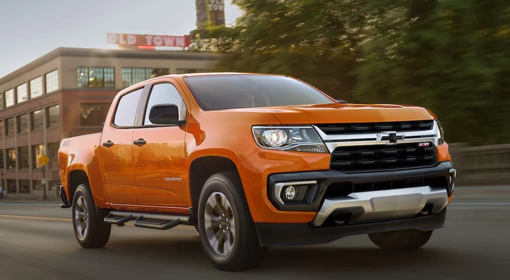 An orange 2021 Chevy Colorado Z71 is shown driving after viewing used cars for sale.