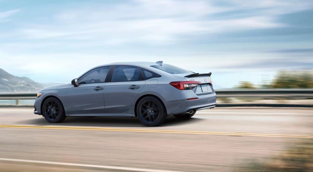 A grey 2023 Honda Civic Si driving on a blurred road.