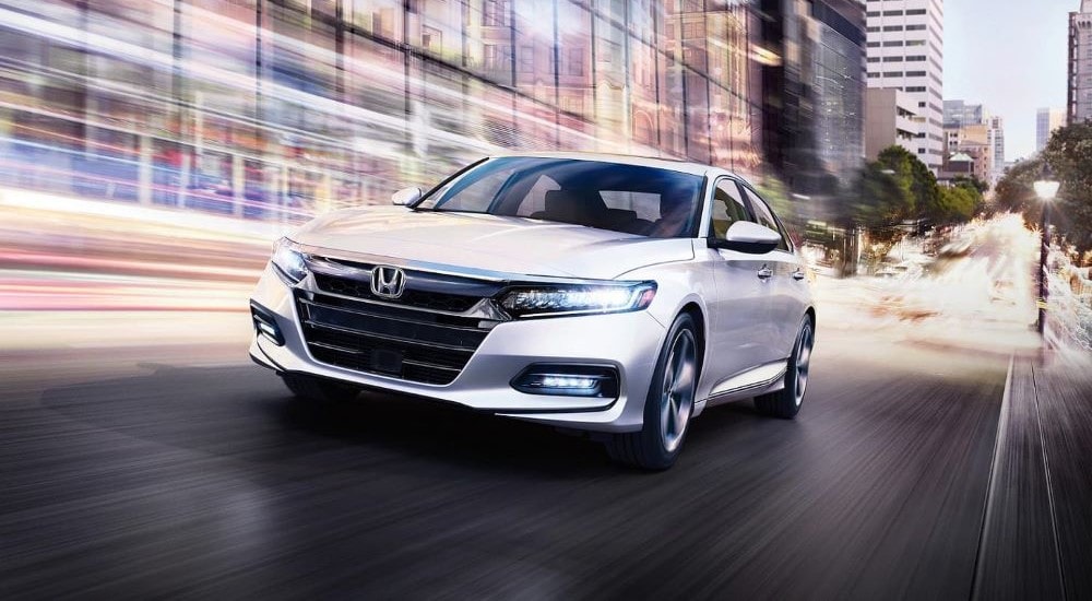 2020%20Honda%20Accord%20Touring%20-%20White%20%202.jpg A white 2020 Honda Accord is shown driving near city buildings.