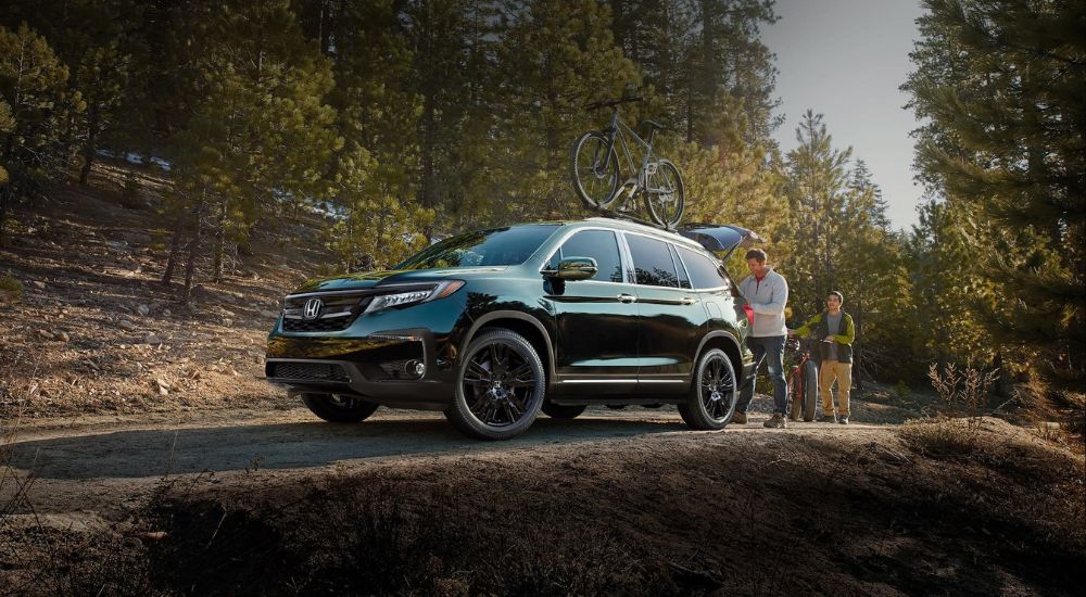 A black 2022 Honda Pilot Elite is shown on a trail after looking for used cars for sale near Ruston.