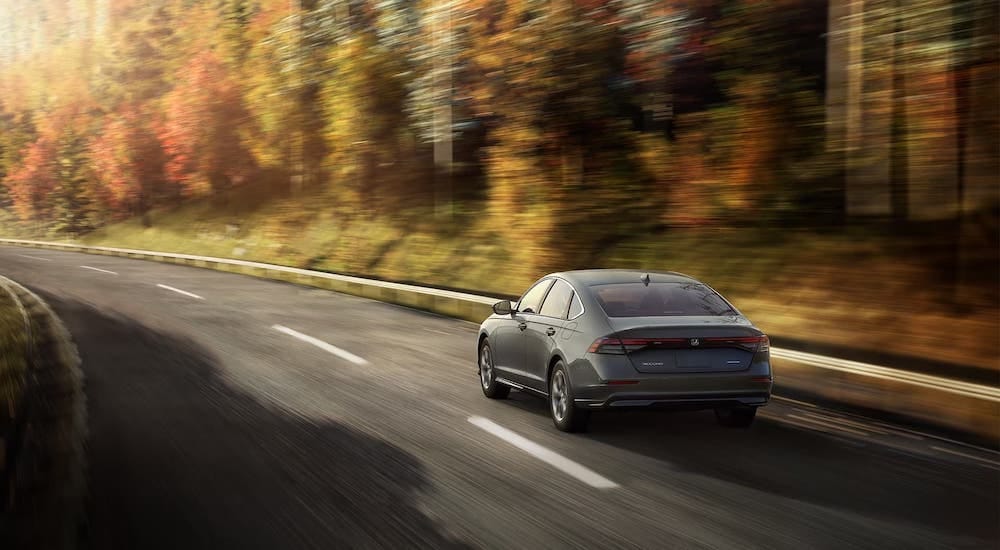 Rear view of a grey 2024 Honda Accord driving away.