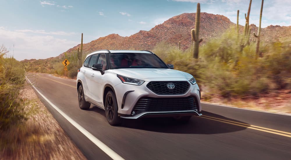 A white 2022 Toyota Highlander XSE is shown driving near a cactus.