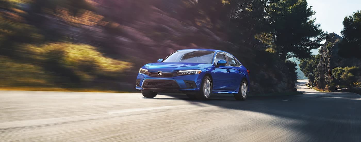 A blue 2022 Honda Civic LX is shown driving on an open road after leaving a HOnda dealership near Ruston, LA.