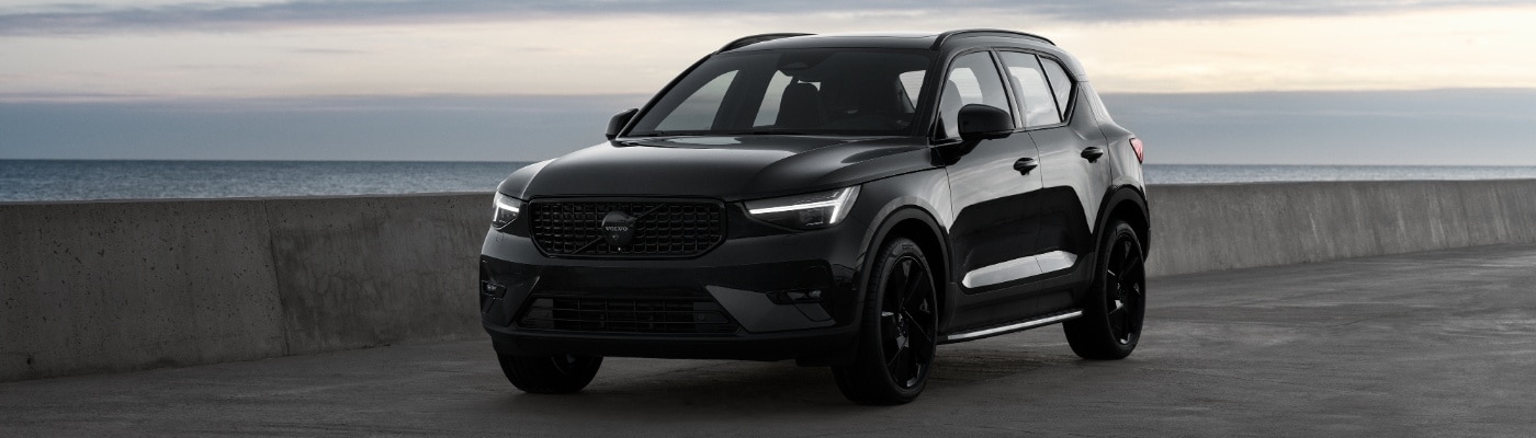 Green Volvo XC40 on a sea-front bridge