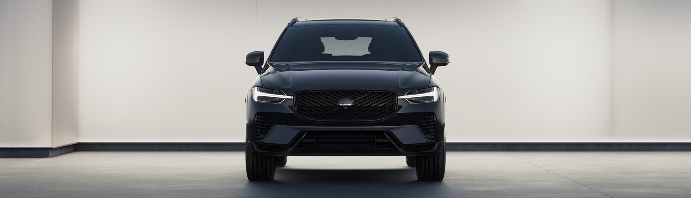 Dark colored Volvo XC60 Black Edition pictured in low lighting with headlights on