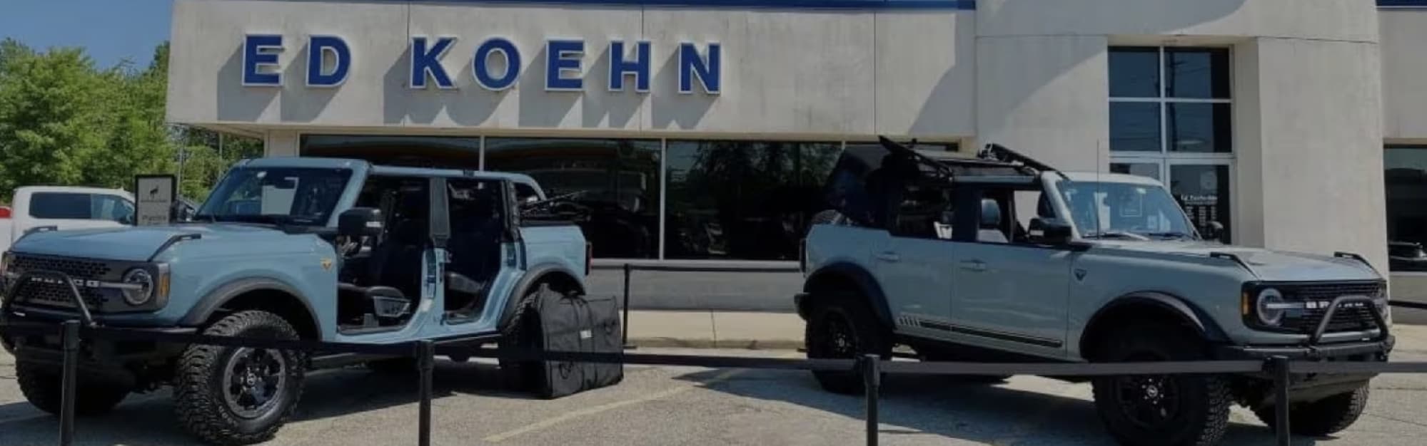 Two Ford Bronco SUVs parked outside the Ed Koehn Ford of Wayland dealership