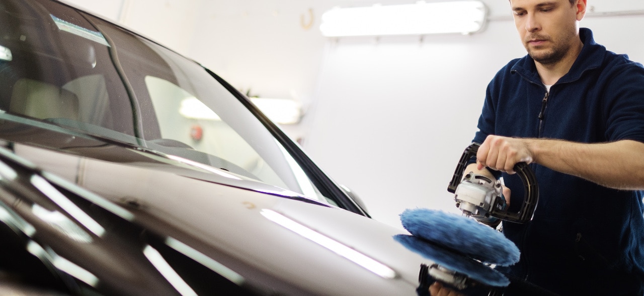 man polishes car paint