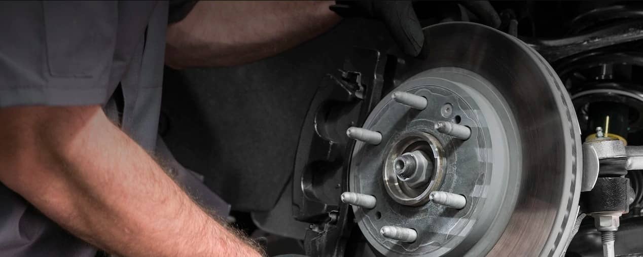 Technician replacing a disc brake pad