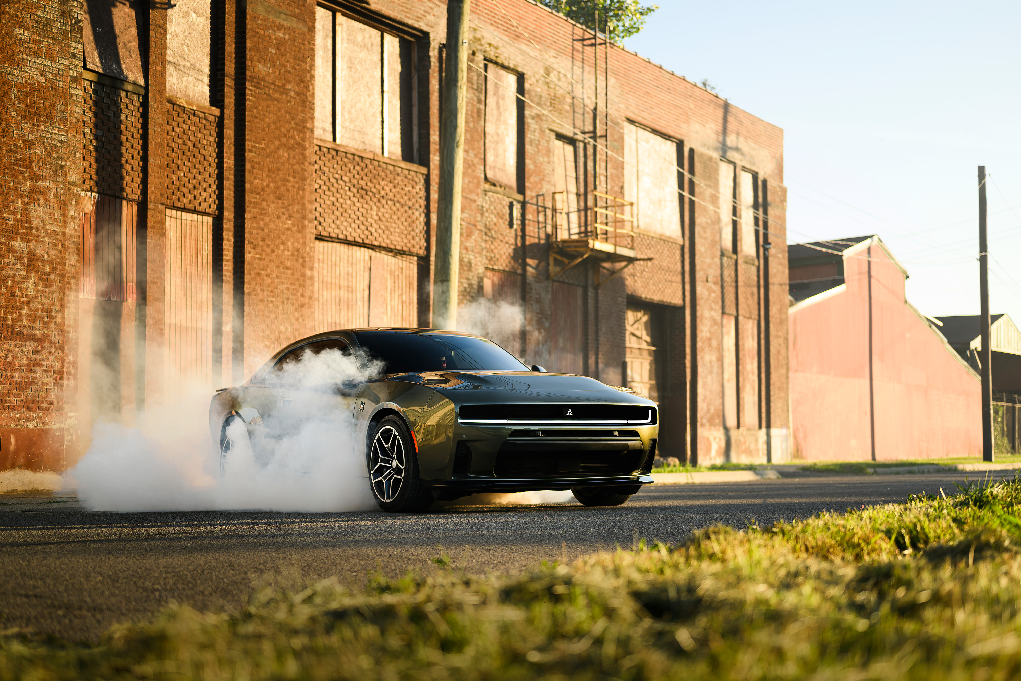 Dodge Charger burnout beside a brick building