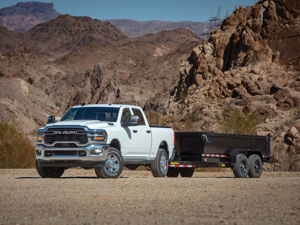 White Ram 2500 crew cab towing a trailer in the desert