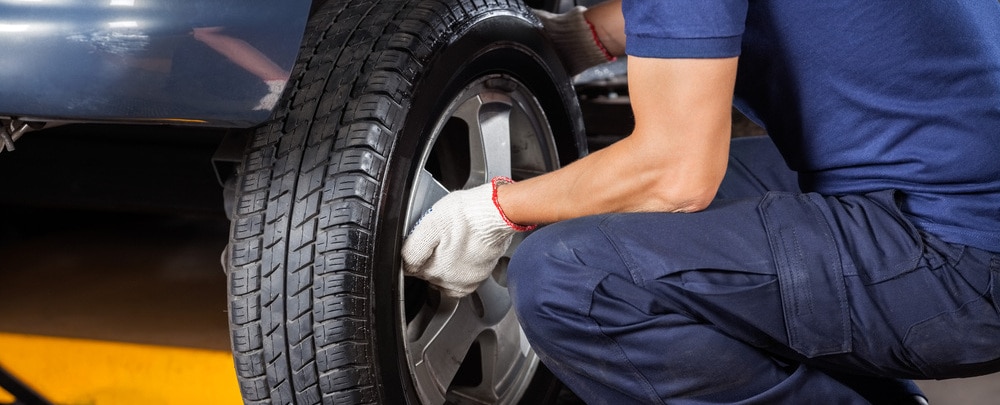 Mechanic changing a wheel of a modern car