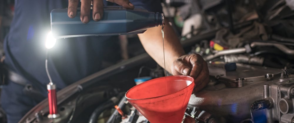 Male adding oil with a funnel
