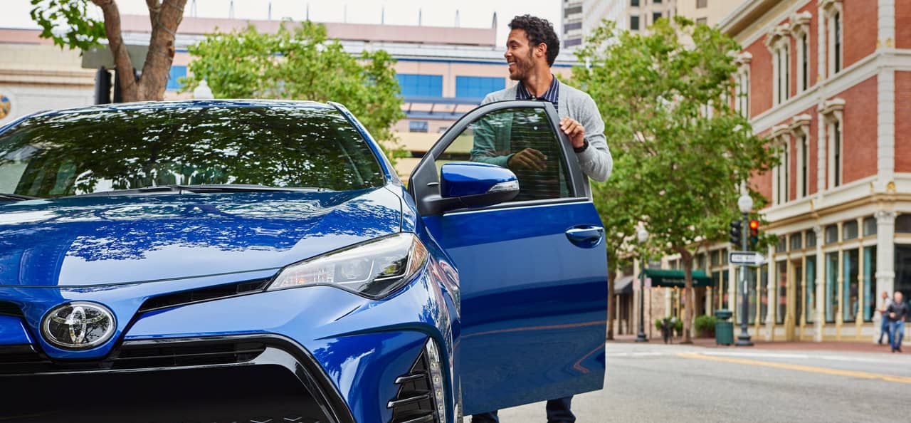 man exits Toyota Corolla